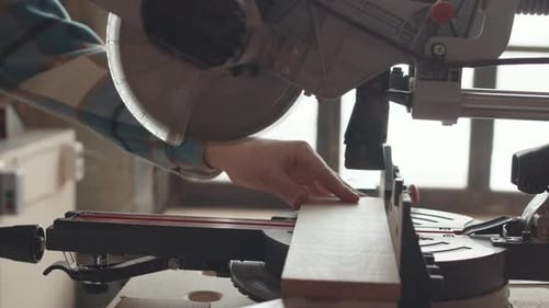 Woodworker Cuts Wood with a Chop Saw in Workshop