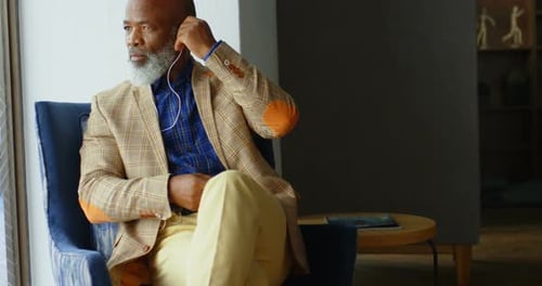 Senior Businessman Listening to Music on Headphones in Office 4 K 4k
