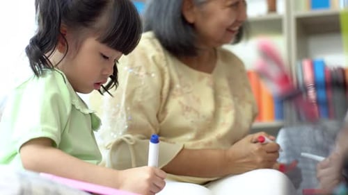 Child Drawing with Grandmother at Home