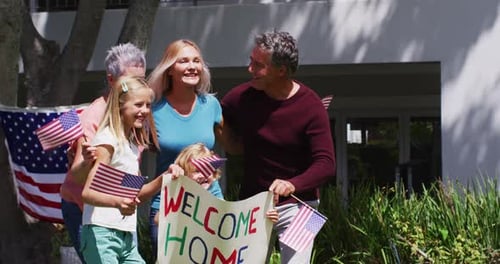 Caucasian military man in uniform hugging his family in the garden