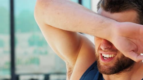 Sweaty Man Wipes Face After Exercise
