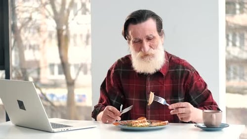 Senior Man Eating Meal at Table Indoors