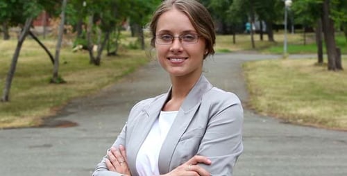 Smiling Woman Standing with Arms Crossed in Park