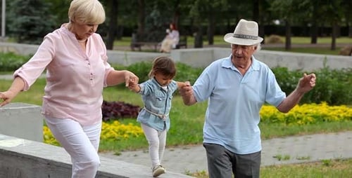 Child Walking With Grandparents in a City Park