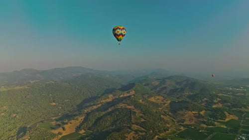 Hot air balloon rising over small town in the Napa Valley