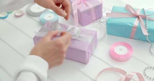 Hands packed Christmas gifts into paper boxes. New Year holidays. Gift wrapping.