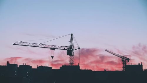 City Construction Cranes at Colorful Dawn