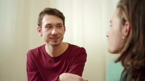 Two Young Adults in Conversation Indoors