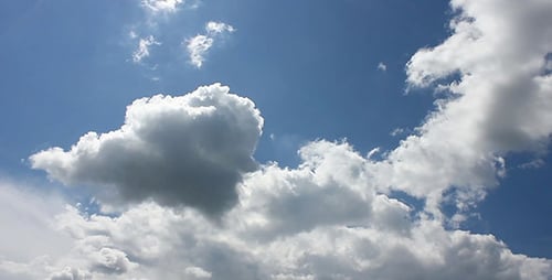 Fluffy White Clouds float in the Blue Sky