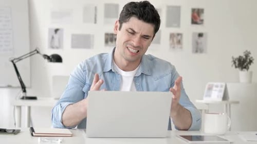 Frustrated Man Reacting Negatively to Laptop
