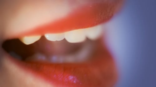 Woman's Mouth Close Up With Shiny Red Lipstick