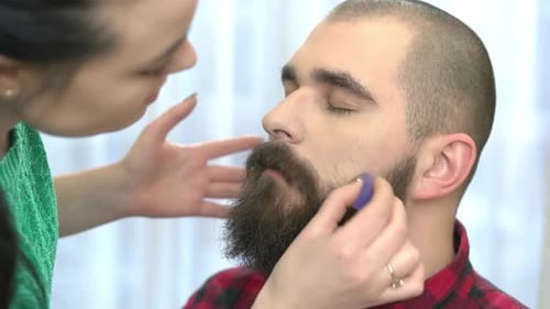 Makeup Artist Applying Makeup to Bearded Man