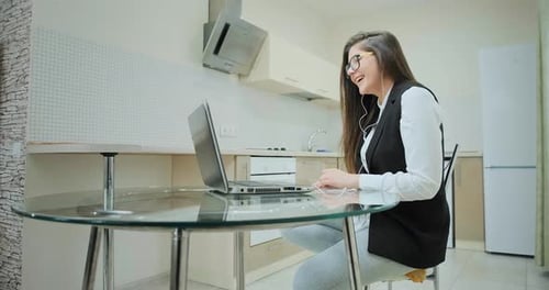 Woman Chatting on Laptop in Bright Kitchen