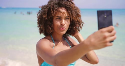 Cheerful Ethnic Woman Taking Selfie on Beach