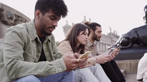 Young Adults Using Phones Together in the City