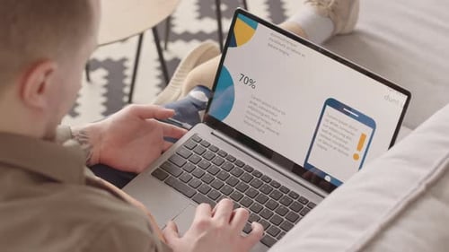 Young Adult Analyzing Marketing Statistics on Laptop