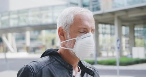 Caucasian man out and about in the street wearing on a face mask against coronavirus
