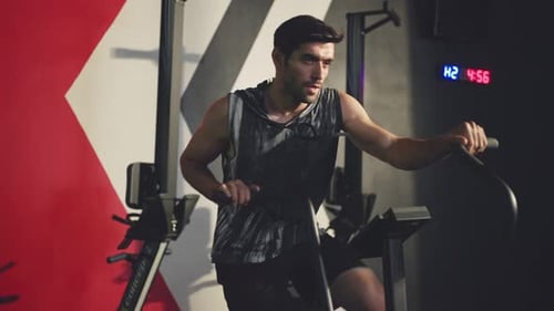 Caucasian attractive sport fitness male trainer sit on stationary bicycle exercise in gym or stadium