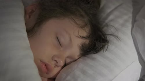 Child Sleeps Peacefully in Bed at Home