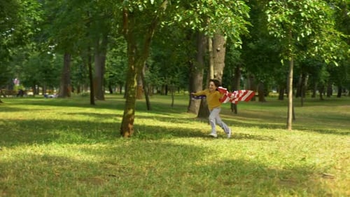 Child Runs With American Flag in Green Park