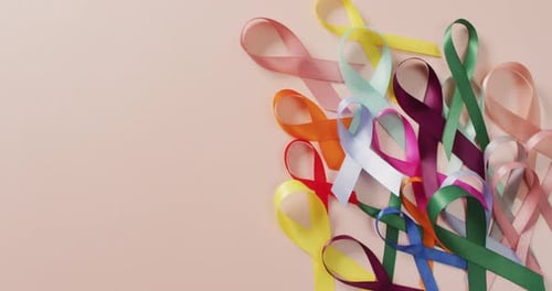 Colorful Awareness Ribbons on Pink Background