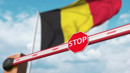 Se abre la puerta de la barrera con la bandera de Bélgica como fondo