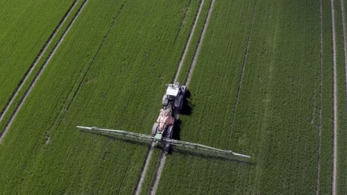 Tractor Sprays Field from Above on Farm