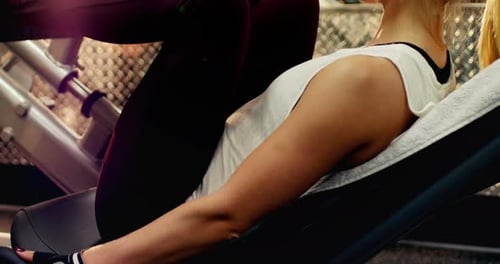 Woman Uses Leg Press Machine at the Gym