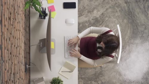 Top view of smiling Asian business woman, person working from home, typing on a keyboard