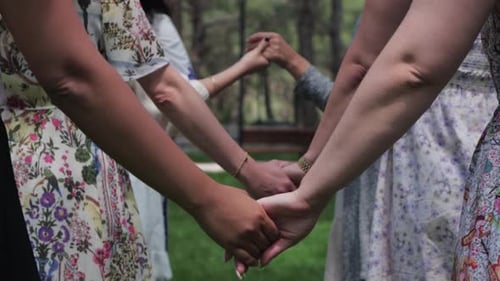 Women Holding Hands Together in a Circle