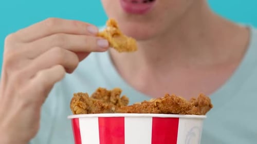 Person Enjoys Fried Chicken Bucket Close Up