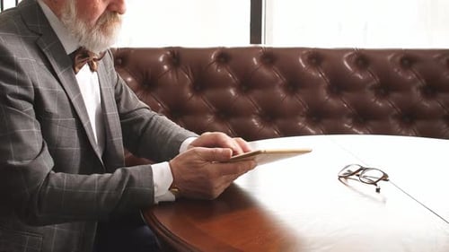 Handsome Old Man Working on Digital Tablet in Home Office.