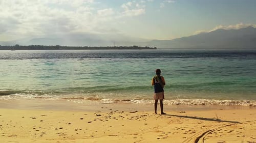 Fishing rod for cute man on vacation hanging out at beach on summer white sandy and blue 4K backgrou