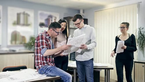 Architects Collaborating on Blueprints in Office Environment