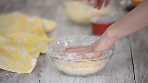 Une fille dans la cuisine assemble une génoise à la crème dans un bol