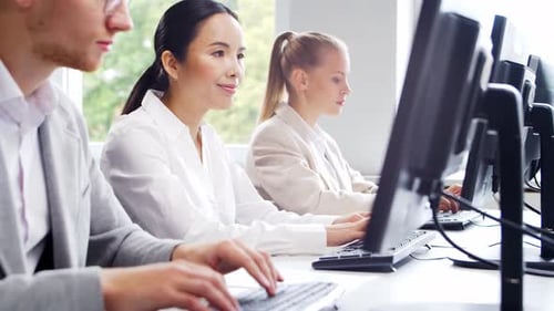 Diverse team of young professionals is working in the phone support office.