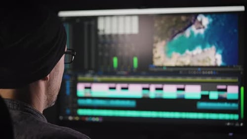Video Editor Looking at Editing Software on Computer