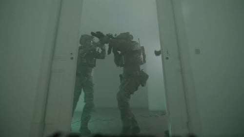 Soldiers storming into a room carrying rifles