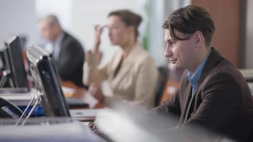 Side View Portrait of Focused Handsome Caucasian Man Working Online in Office