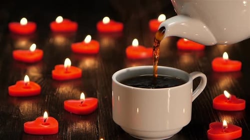 Pouring Hot Drink Surrounded by Red Heart Candles