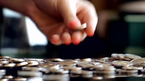 Pouring Coins from Jar onto Reflective Surface