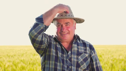 Trabajador agrícola feliz poniéndose el sombrero