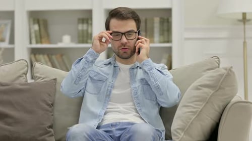 Man Talking on Phone in Living Room Setting