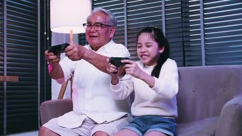 Grandfather and Granddaughter Excitedly Play Video Game Together