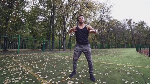 Man doing stretching exercise. Fitness man preparing for workout in the park