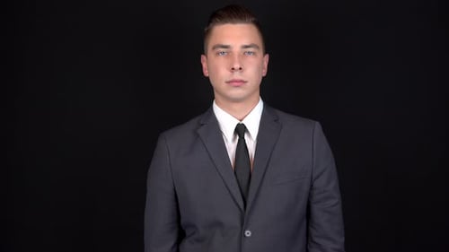 Young Man in Suit Against Black Backdrop
