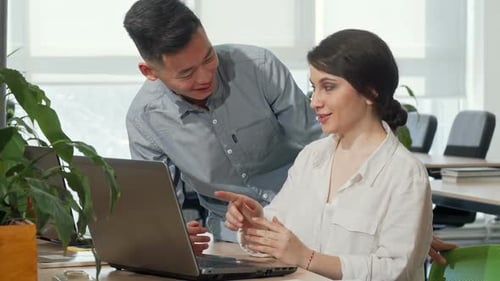 Asiatischer Geschäftsmann diskutiert mit seiner Kollegin über Startup-Ideen