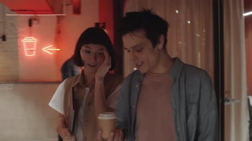 Male and Female Colleagues Chatting and Walking in Coworking Office
