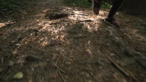 Close View of Girl in Sports Shoes Running Uphill on Forest Path