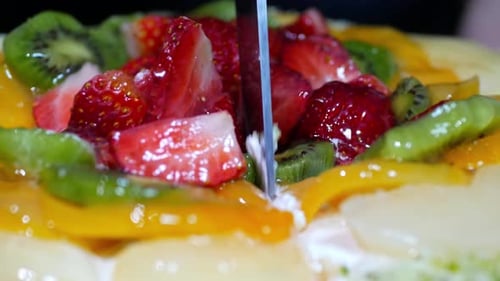 Cutting a Colorful Fruit Cake Dessert